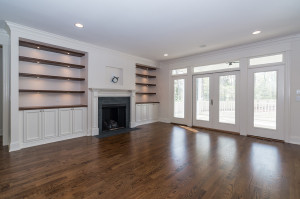 Family room with hardwood floors and built in shelves and cabinets