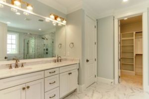 Bathroom vanity area and view into walk in closet